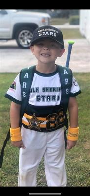 Child wearing a Polk Sheriff's Charities sports uniform